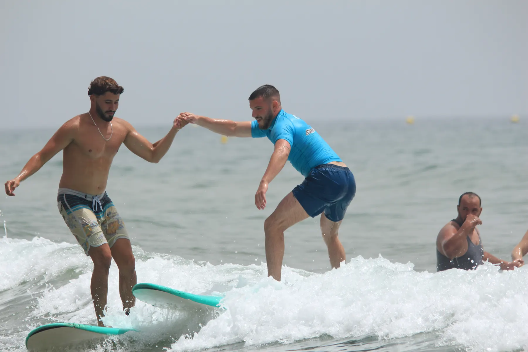 Ahmed coaching a surfer in the water